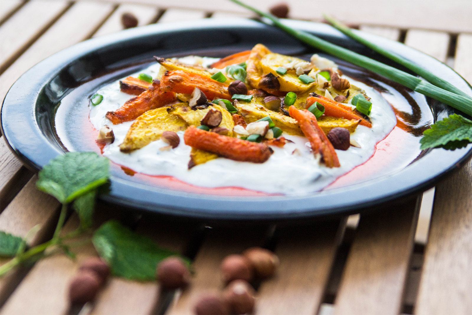 Im Ofen geröstete Rohnen und Karotten auf Kräuter-Joghurt mit gehackten Haselnüssen